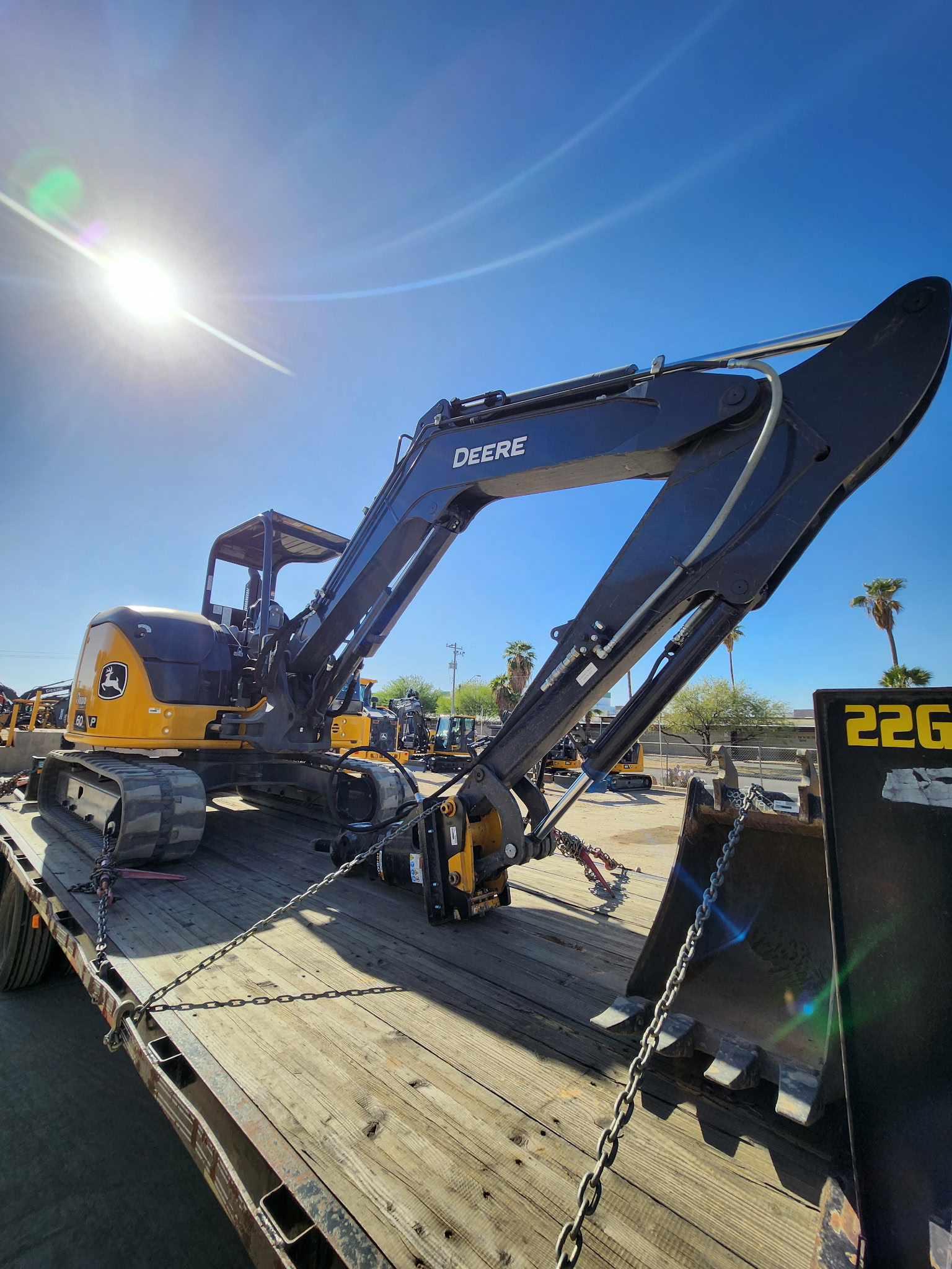 Deere excavator on the lowboy with a sun flare