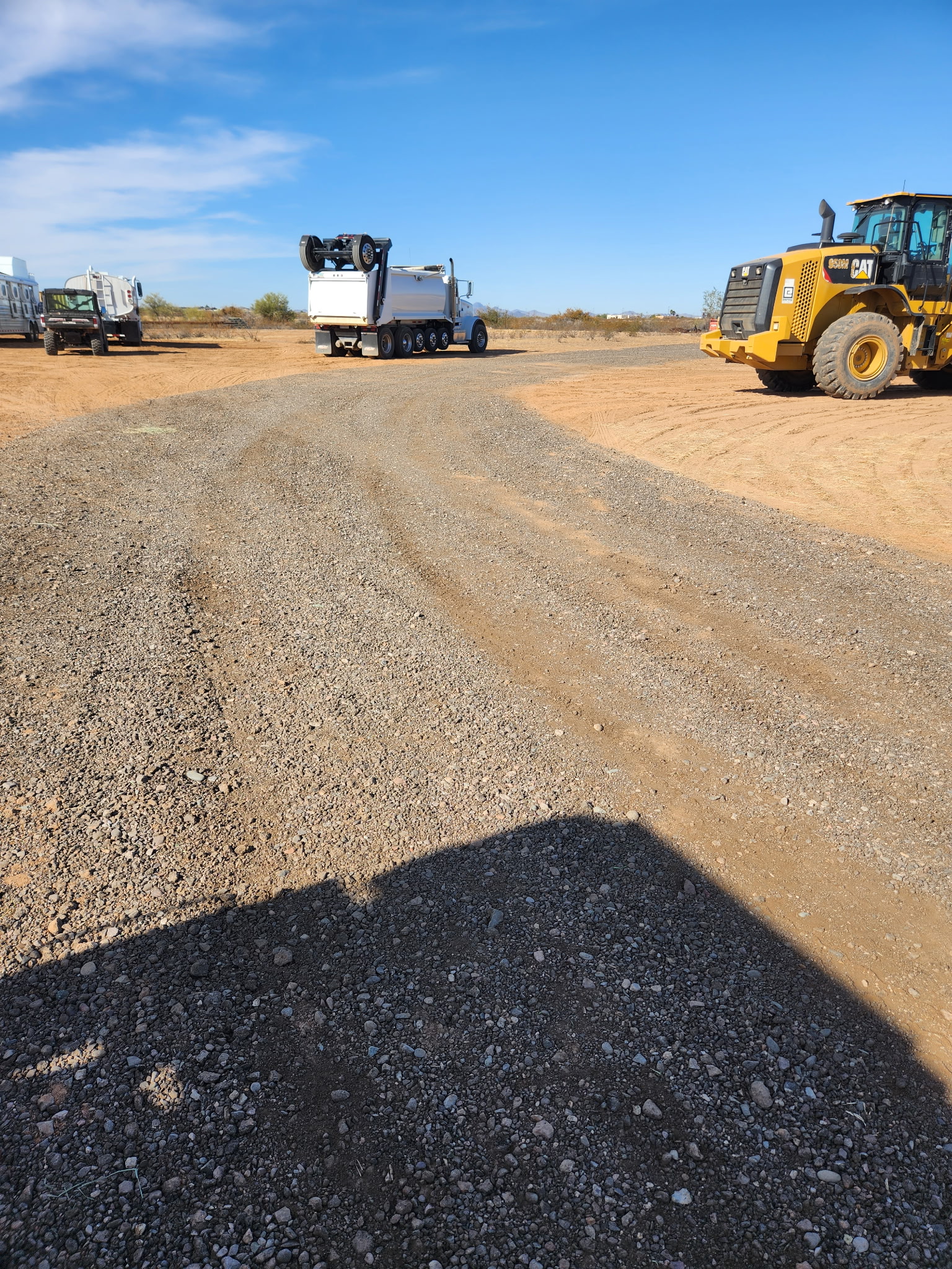 Equipment staged along a dirt access road