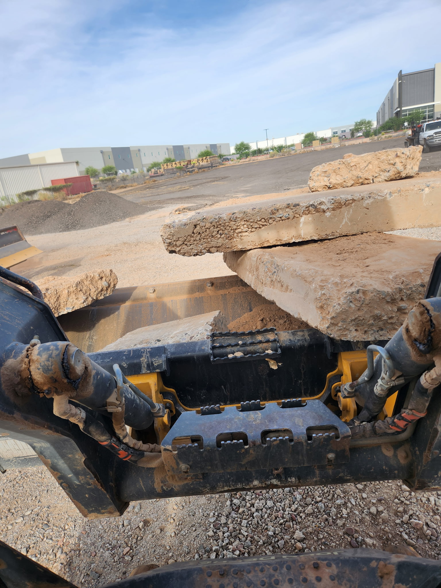 Skid steer bucket close-up, dust in the light