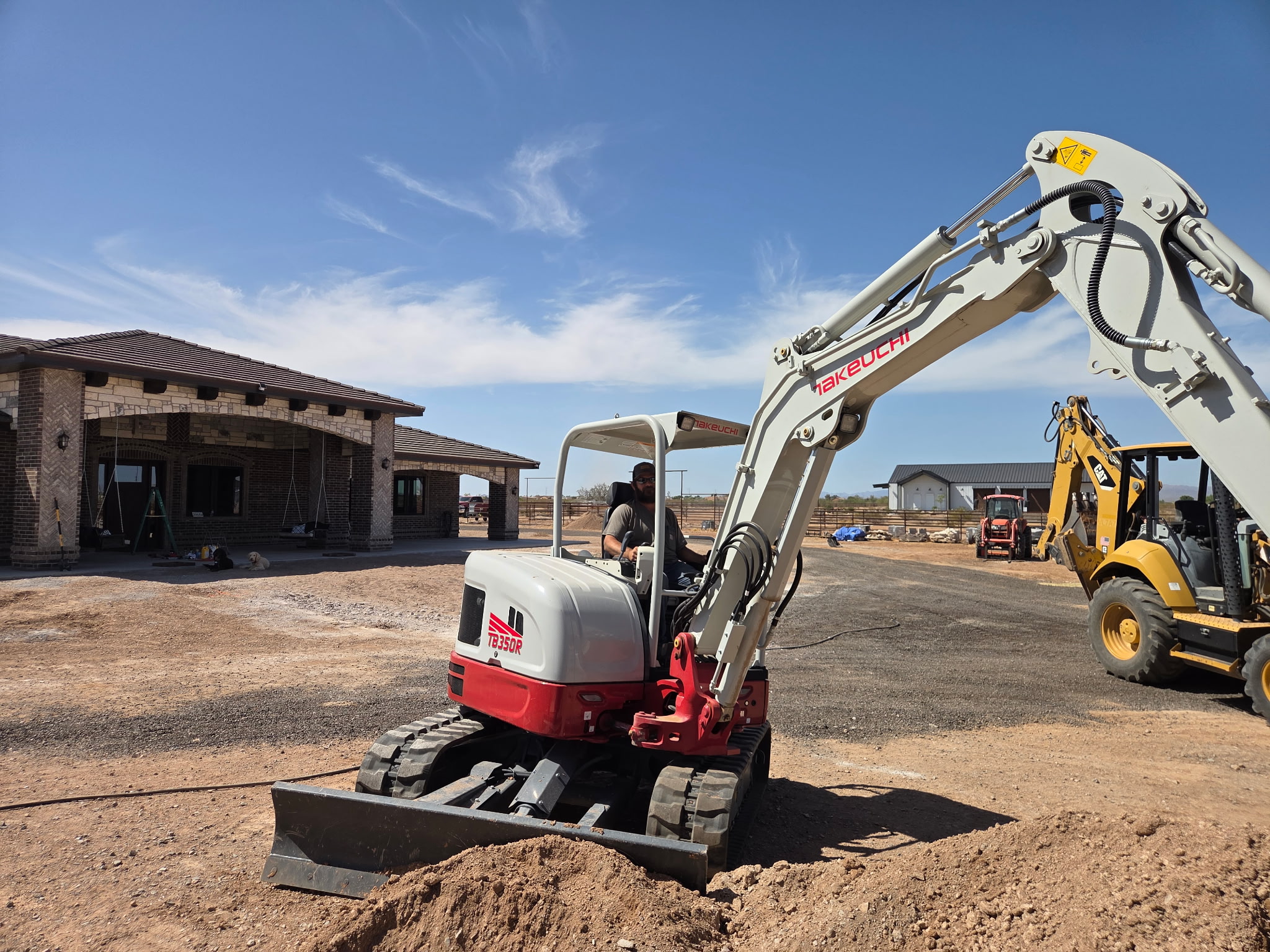 Takeuchi mini working a wall install at a residence