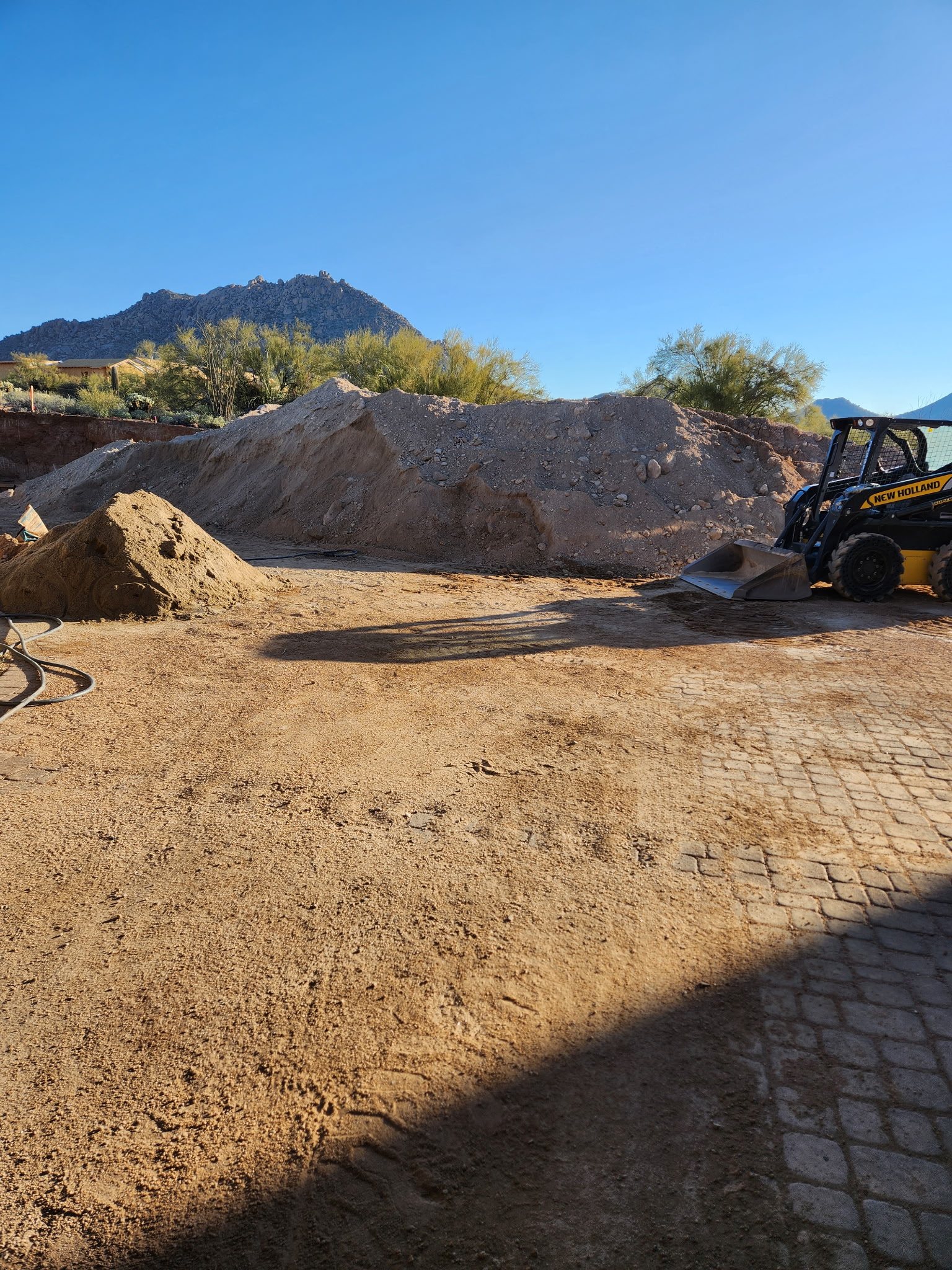 CAT wheel loader parked at the yard with the mountain behind