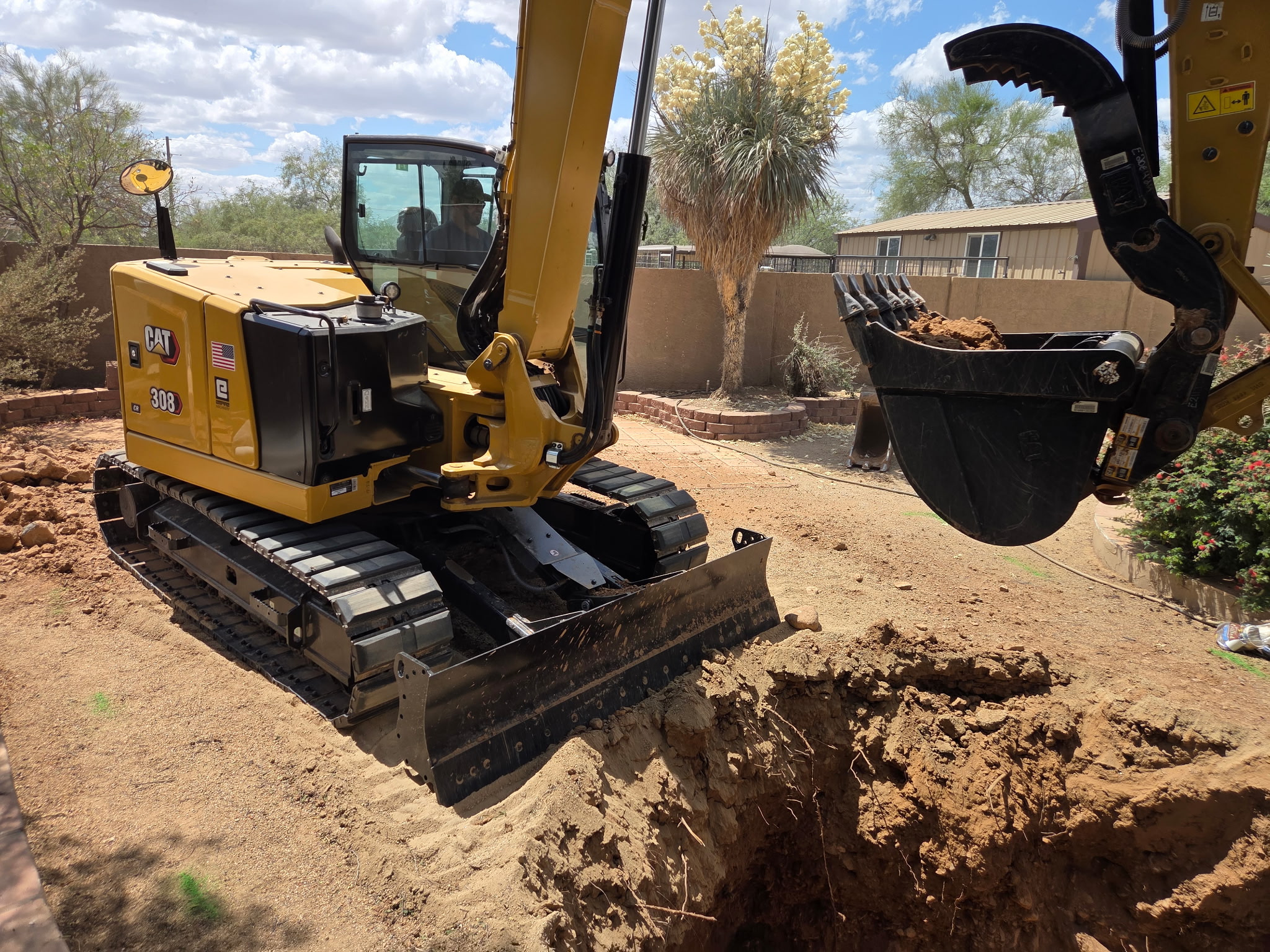 Deere mini-excavator digging near saguaros