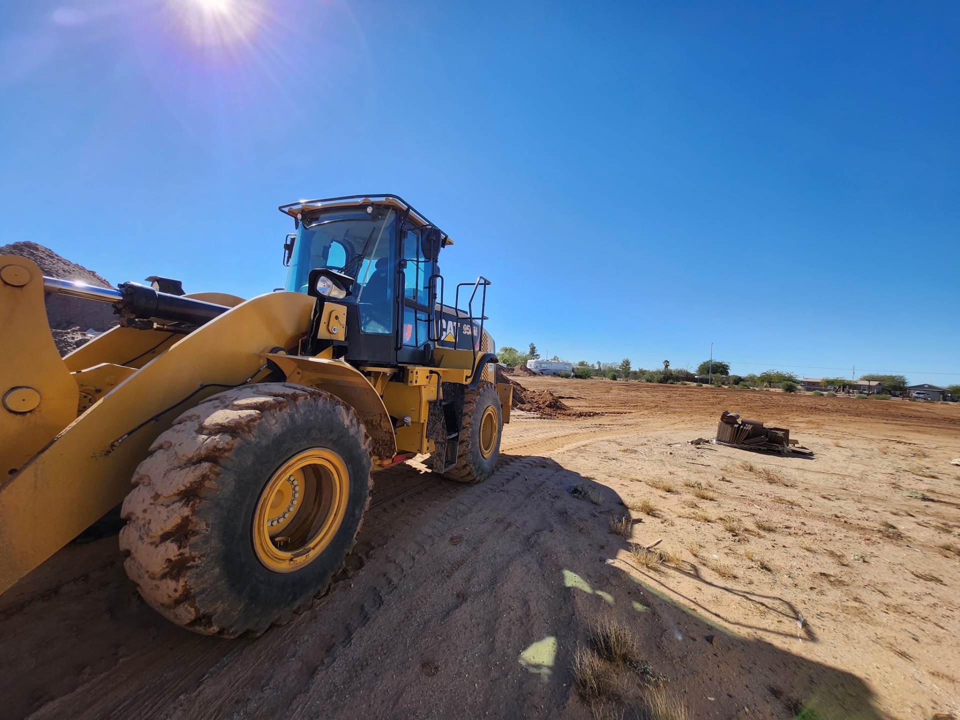 CAT 950M wheel loader with sun flare on an Arizona jobsite