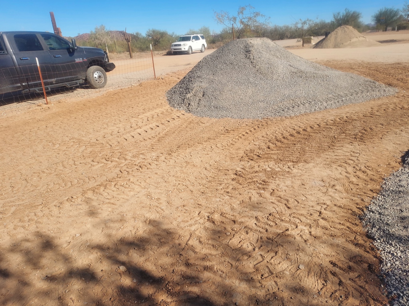 Fresh gravel pad prep with a pile of decomposed granite in the desert