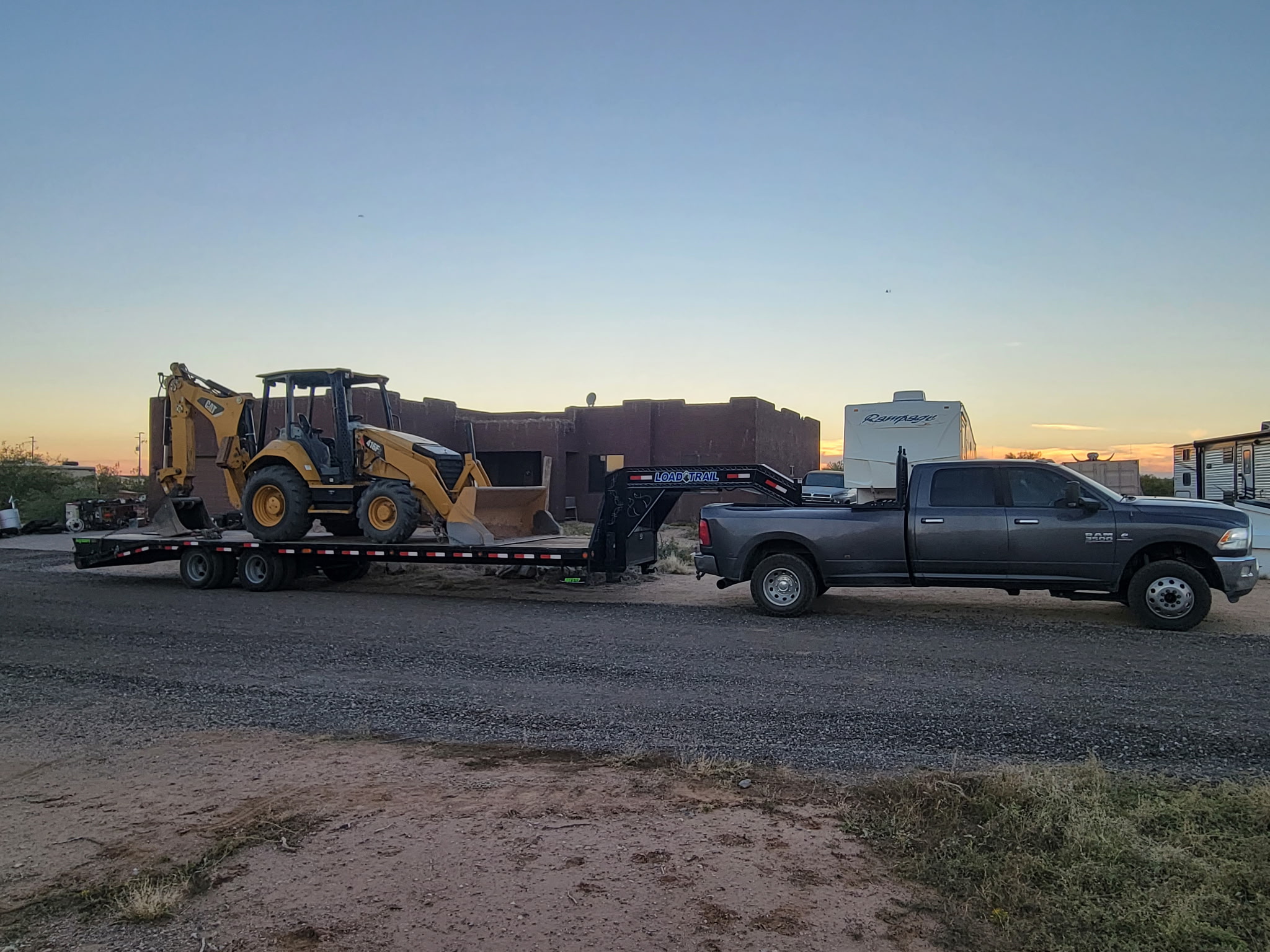 Backhoe chained to the trailer at sunset