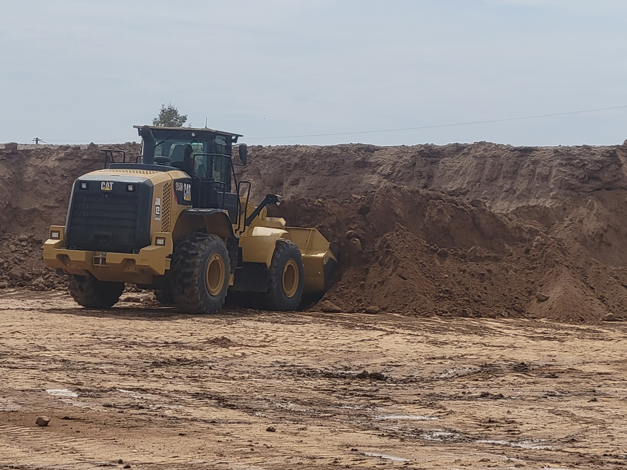 CAT 950M pushing a stockpile of desert fill