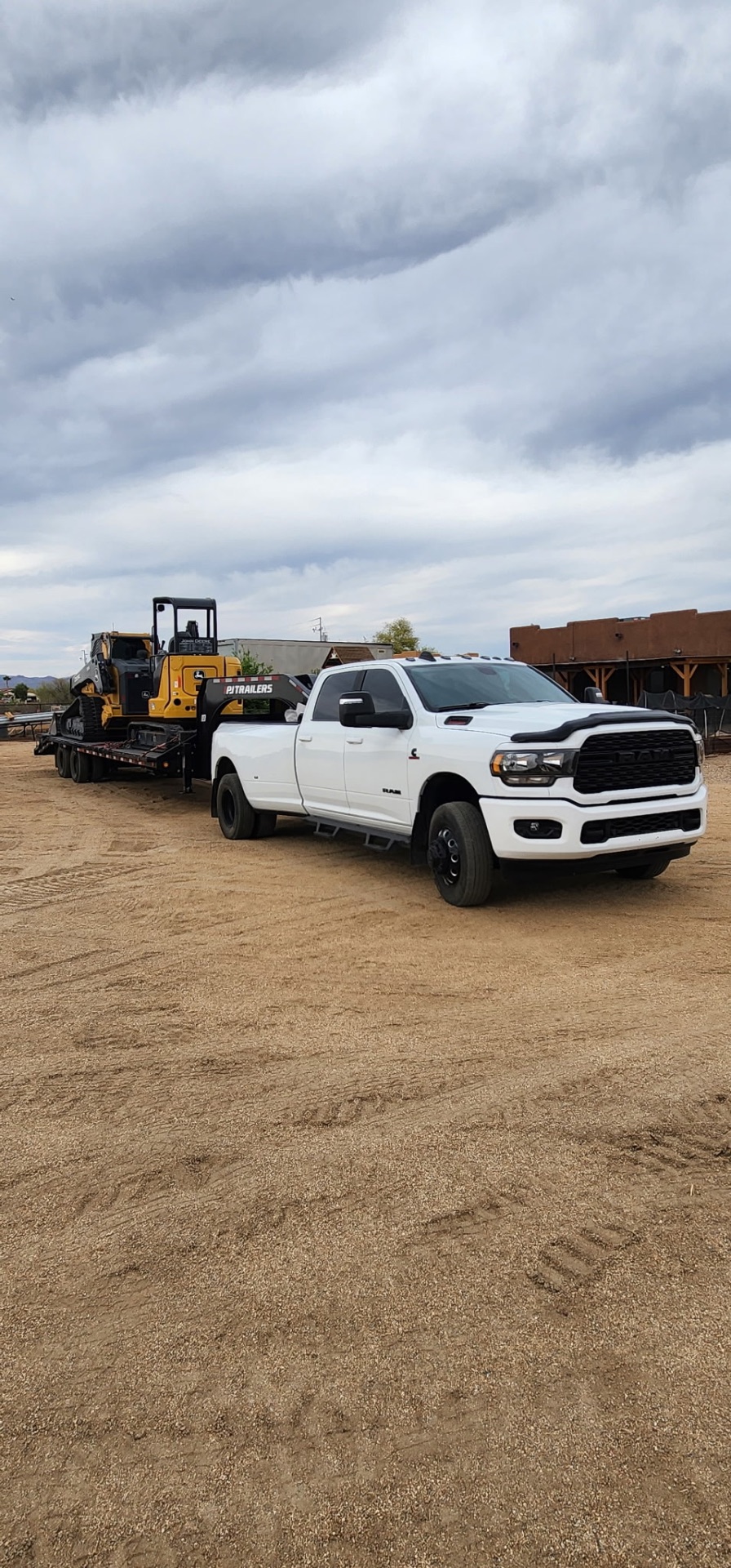 Ram dually hauling the Deere skid steer on a PJ gooseneck trailer